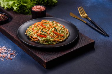 Beton zemin üzerinde ince dilimlenmiş havuç ve kabak salatası. Vejetaryen mutfağı