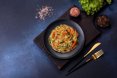 Beton zemin üzerinde ince dilimlenmiş havuç ve kabak salatası. Vejetaryen mutfağı