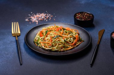 Beton zemin üzerinde ince dilimlenmiş havuç ve kabak salatası. Vejetaryen mutfağı