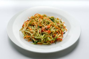 Beton zemin üzerinde ince dilimlenmiş havuç ve kabak salatası. Vejetaryen mutfağı