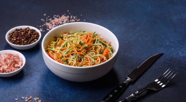 Beton zemin üzerinde ince dilimlenmiş havuç ve kabak salatası. Vejetaryen mutfağı