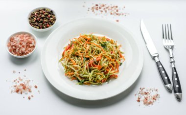 Beton zemin üzerinde ince dilimlenmiş havuç ve kabak salatası. Vejetaryen mutfağı