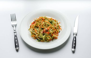 Beton zemin üzerinde ince dilimlenmiş havuç ve kabak salatası. Vejetaryen mutfağı