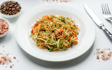 Beton zemin üzerinde ince dilimlenmiş havuç ve kabak salatası. Vejetaryen mutfağı