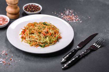 Beton zemin üzerinde ince dilimlenmiş havuç ve kabak salatası. Vejetaryen mutfağı