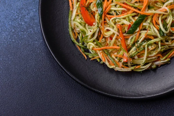 Beton zemin üzerinde ince dilimlenmiş havuç ve kabak salatası. Vejetaryen mutfağı