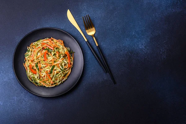 Beton zemin üzerinde ince dilimlenmiş havuç ve kabak salatası. Vejetaryen mutfağı