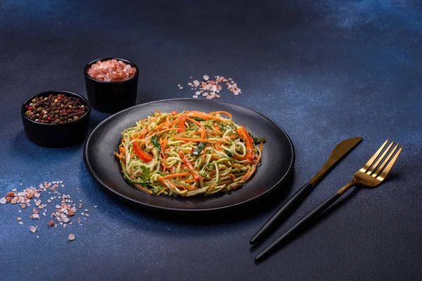 Beton zemin üzerinde ince dilimlenmiş havuç ve kabak salatası. Vejetaryen mutfağı