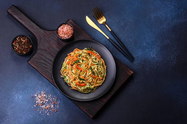 Beton zemin üzerinde ince dilimlenmiş havuç ve kabak salatası. Vejetaryen mutfağı