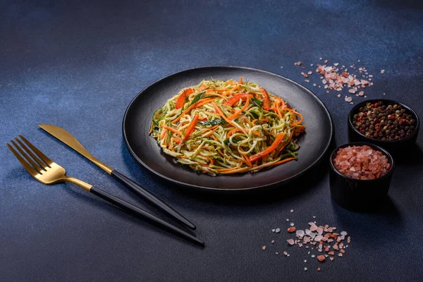 Beton zemin üzerinde ince dilimlenmiş havuç ve kabak salatası. Vejetaryen mutfağı