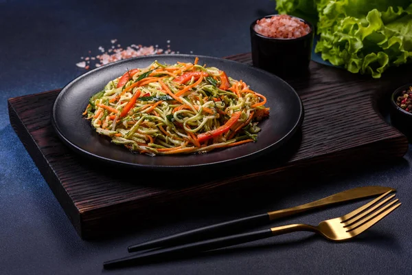 Beton zemin üzerinde ince dilimlenmiş havuç ve kabak salatası. Vejetaryen mutfağı