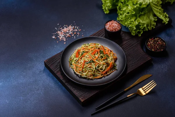 Beton zemin üzerinde ince dilimlenmiş havuç ve kabak salatası. Vejetaryen mutfağı