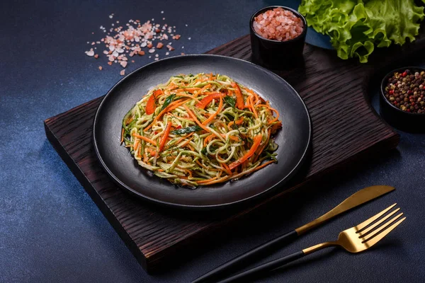 Beton zemin üzerinde ince dilimlenmiş havuç ve kabak salatası. Vejetaryen mutfağı