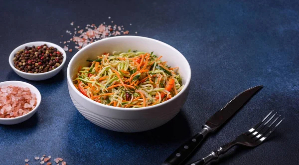 Beton zemin üzerinde ince dilimlenmiş havuç ve kabak salatası. Vejetaryen mutfağı