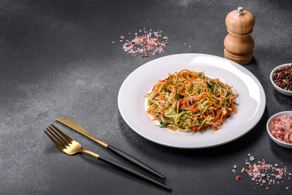 Beton zemin üzerinde ince dilimlenmiş havuç ve kabak salatası. Vejetaryen mutfağı