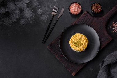 Mısır taneli yengeç salatası, porsiyon olarak siyah bir tabağa serilmiş, bayram sofrasında servis ediliyor.