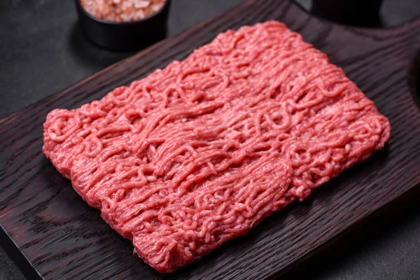 Raw mince beef, ground meat on a black background. Copy space