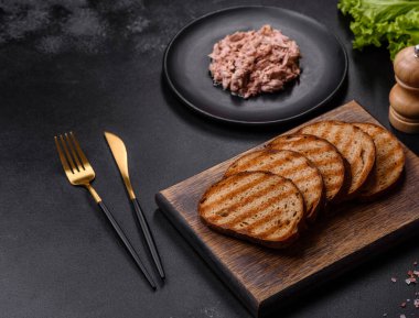 Kaynamış yumurta, otlar ve tereyağlı lezzetli sağlıklı bir sandviç yapmak için konserve ton balığı ve kızarmış ekmek.