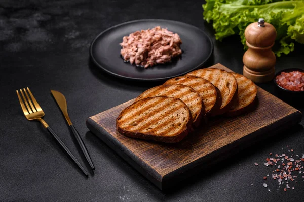 Kaynamış yumurta, otlar ve tereyağlı lezzetli sağlıklı bir sandviç yapmak için konserve ton balığı ve kızarmış ekmek.