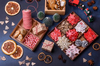 Noel ağacı ahşap oyuncakları beyaz ve kırmızı renklerde, zencefilli ekmek ve kurutulmuş limon ve greyfurt dilimleri Noel kompozisyonu kapsamında