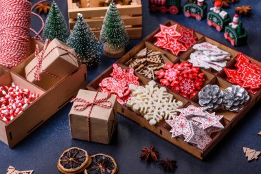 Noel ağacı ahşap oyuncakları beyaz ve kırmızı renklerde, zencefilli ekmek ve kurutulmuş limon ve greyfurt dilimleri Noel kompozisyonu kapsamında