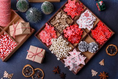 Noel ağacı ahşap oyuncakları beyaz ve kırmızı renklerde, zencefilli ekmek ve kurutulmuş limon ve greyfurt dilimleri Noel kompozisyonu kapsamında