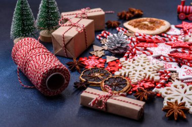 Noel ağacı ahşap oyuncakları beyaz ve kırmızı renklerde, zencefilli ekmek ve kurutulmuş limon ve greyfurt dilimleri Noel kompozisyonu kapsamında