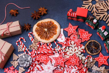 Noel ağacı ahşap oyuncakları beyaz ve kırmızı renklerde, zencefilli ekmek ve kurutulmuş limon ve greyfurt dilimleri Noel kompozisyonu kapsamında