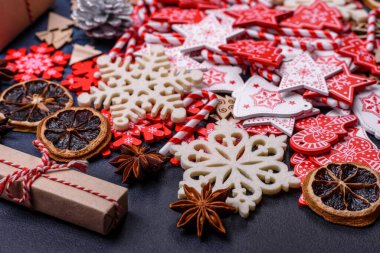 Noel ağacı ahşap oyuncakları beyaz ve kırmızı renklerde, zencefilli ekmek ve kurutulmuş limon ve greyfurt dilimleri Noel kompozisyonu kapsamında