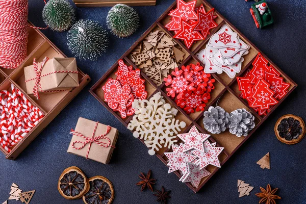 Noel ağacı ahşap oyuncakları beyaz ve kırmızı renklerde, zencefilli ekmek ve kurutulmuş limon ve greyfurt dilimleri Noel kompozisyonu kapsamında