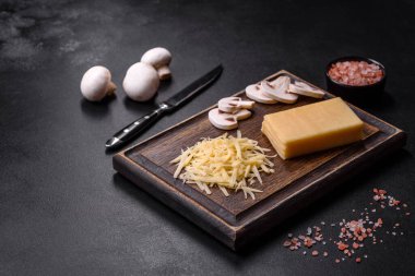 Çiğ makarna, mantar, soğan, kıyma, baharat ve otlar, domates soslu lezzetli bir macun yapmak için koyu beton arka planda.