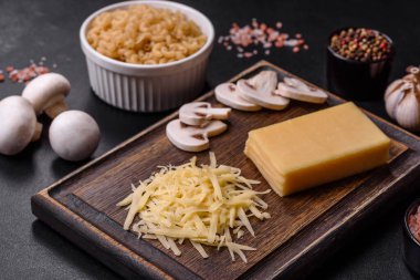 Çiğ makarna, mantar, soğan, kıyma, baharat ve otlar, domates soslu lezzetli bir macun yapmak için koyu beton arka planda.