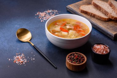 Şehriyeli tavuk çorbası ve sebzeler kırsal beton arka planda. Ev yapımı sağlıklı yemek.