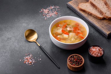 Şehriyeli tavuk çorbası ve sebzeler kırsal beton arka planda. Ev yapımı sağlıklı yemek.