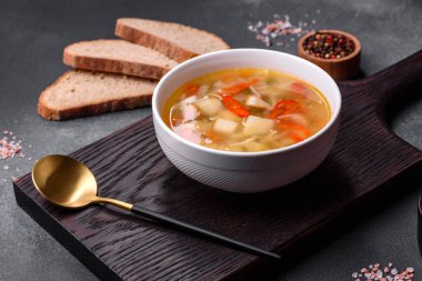 Şehriyeli tavuk çorbası ve sebzeler kırsal beton arka planda. Ev yapımı sağlıklı yemek.