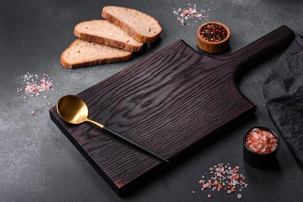 黑色矩形木制切割板 在深色混凝土背景上加盐和香料 在家做饭 — 图库照片