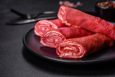 Üzerine pancar suyu, peynir ve yumurta konmuş koyu beton bir zemin üzerinde leziz kırmızı krepler.