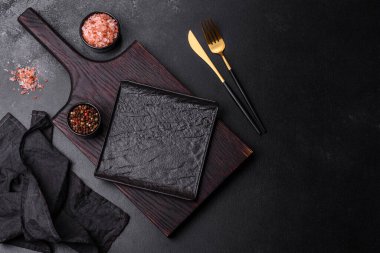 Beton bir masada siyah çatal bıçak takımı. Yemek masası hazırlığı