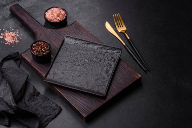 Beton bir masada siyah çatal bıçak takımı. Yemek masası hazırlığı