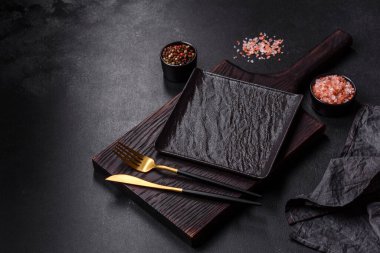 Beton bir masada siyah çatal bıçak takımı. Yemek masası hazırlığı