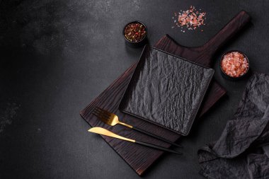 Beton bir masada siyah çatal bıçak takımı. Yemek masası hazırlığı