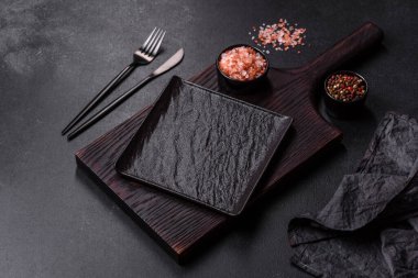 Beton bir masada siyah çatal bıçak takımı. Yemek masası hazırlığı