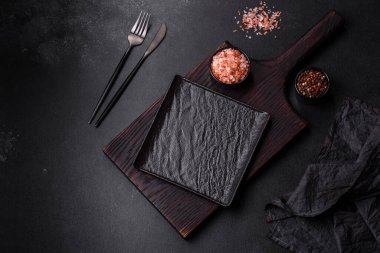 Beton bir masada siyah çatal bıçak takımı. Yemek masası hazırlığı