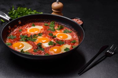 Shakshuka, domates soslu sahanda yumurta, tatlı biber, sarımsak, soğan, baharat ve bitkilerle dolu bir yemek. Yürekli ve lezzetli kahvaltı.