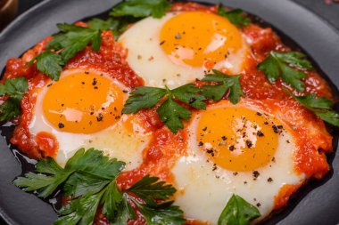 Shakshuka, domates soslu sahanda yumurta, tatlı biber, sarımsak, soğan, baharat ve bitkilerle dolu bir yemek. Yürekli ve lezzetli kahvaltı.