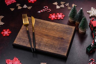 Kahverengi beton arka planda Noel süsleri ve zencefilli çörekler. Festival masası hazırlıyorum.