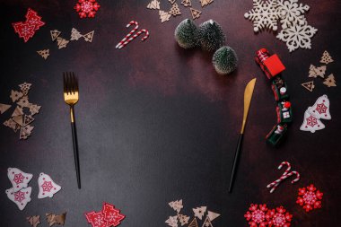 Kahverengi beton arka planda Noel süsleri ve zencefilli çörekler. Festival masası hazırlıyorum.