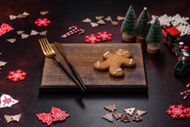 Kahverengi beton arka planda Noel süsleri ve zencefilli çörekler. Festival masası hazırlıyorum.