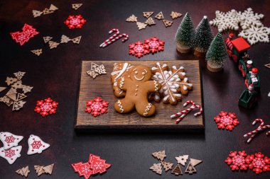 Kahverengi beton arka planda Noel süsleri ve zencefilli çörekler. Festival masası hazırlıyorum.