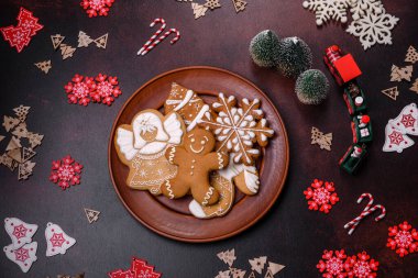 Kahverengi beton arka planda Noel süsleri ve zencefilli çörekler. Festival masası hazırlıyorum.